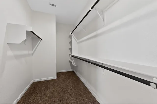 a view of an empty room with ceiling fan