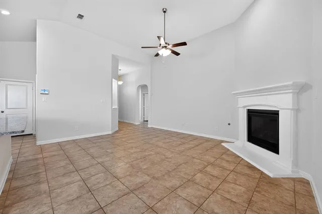 a view of kitchen with stainless steel appliances granite countertop a stove top oven a sink dishwasher and a fireplace with wooden floor
