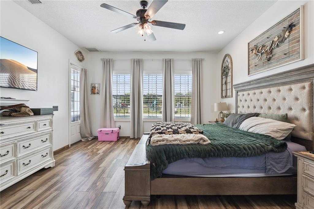 345 Cypress Isles Road Osteen, FL 32764 - Photo 13 of 41 a bedroom with a bed and a chandelier