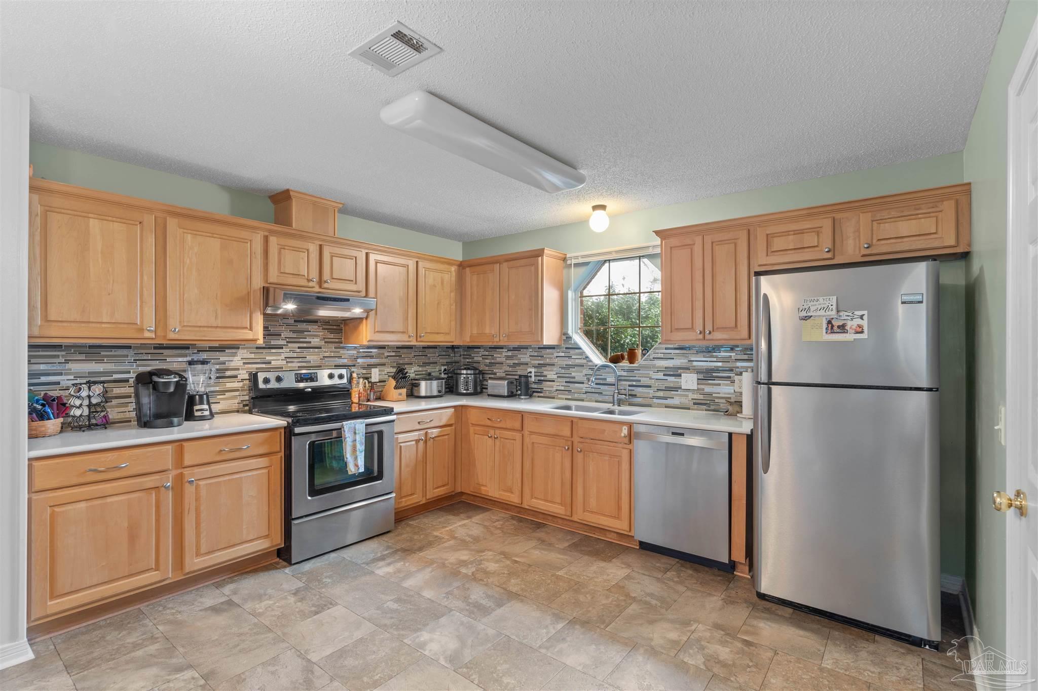 1342 Mazurek Boulevard Pensacola, FL 32514 - Photo 12 of 36 a kitchen with stainless steel appliances granite countertop a refrigerator sink and stove
