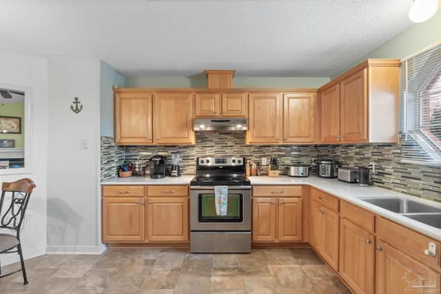 a kitchen with stainless steel appliances a stove sink and cabinets