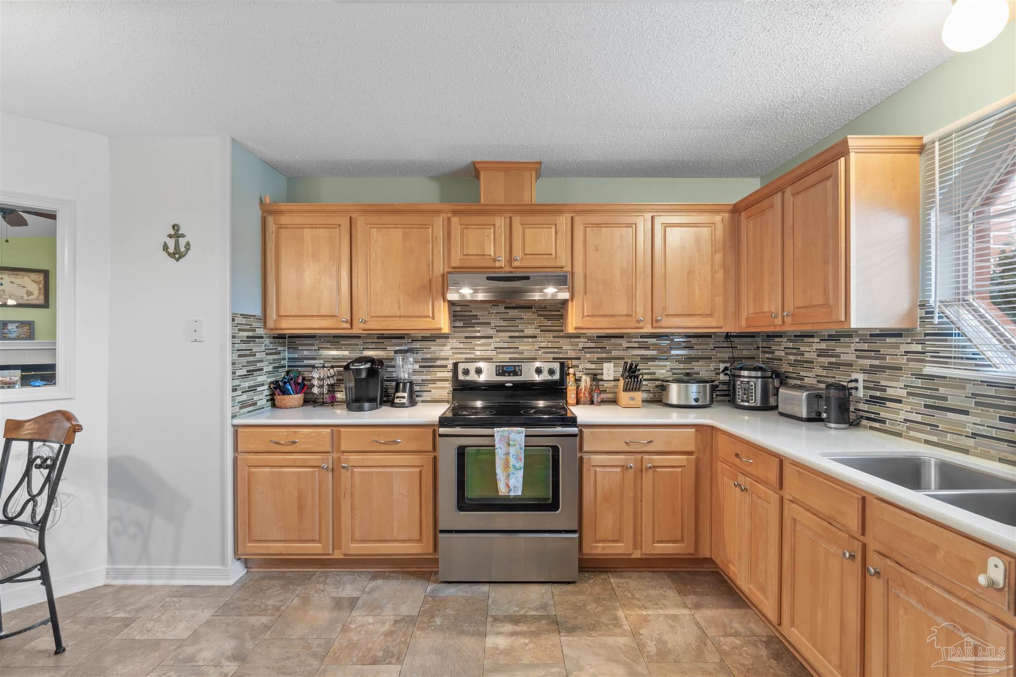 1342 Mazurek Boulevard Pensacola, FL 32514 - Photo 13 of 36 a kitchen with a stove top oven sink and cabinets