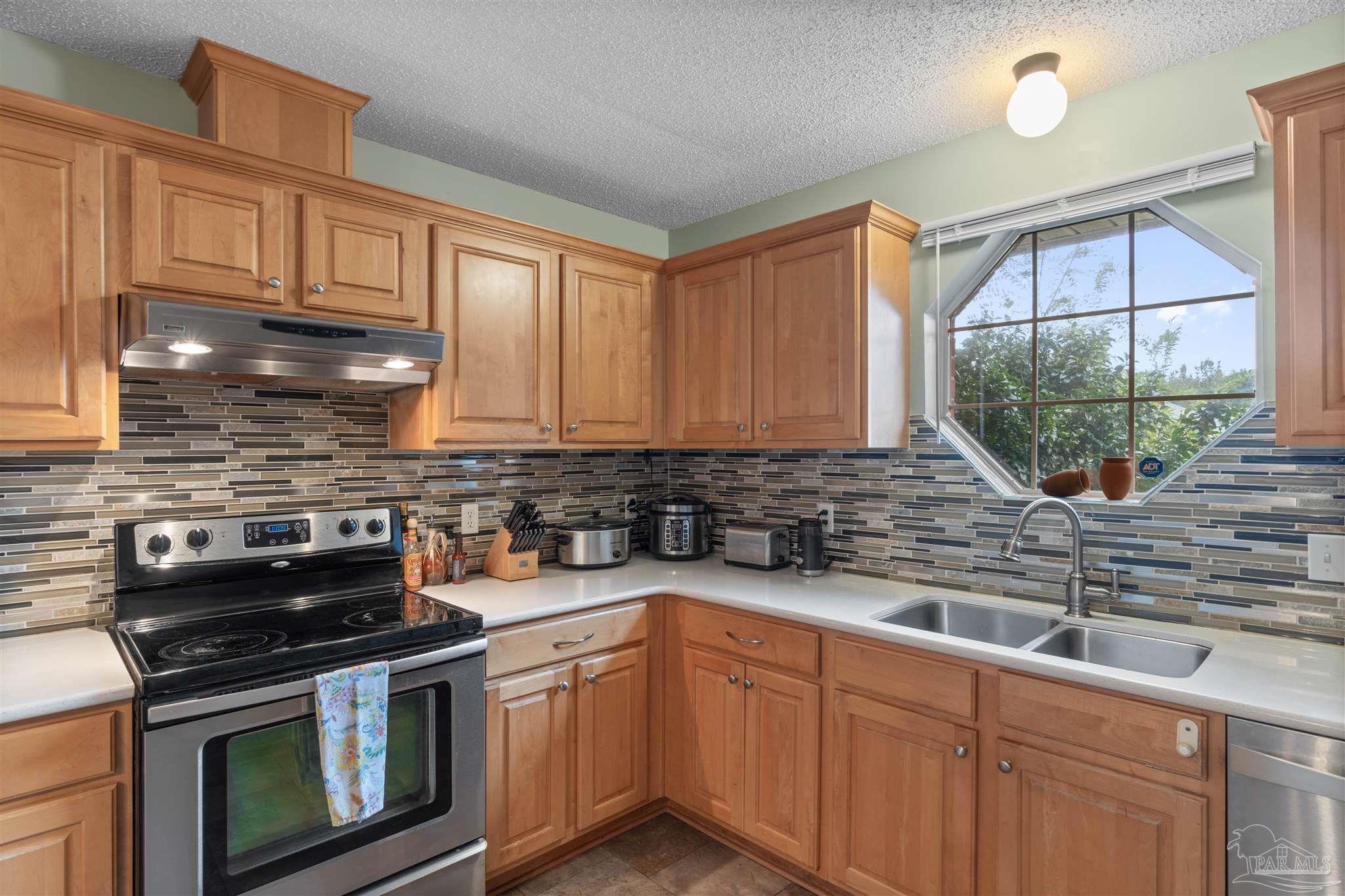 1342 Mazurek Boulevard Pensacola, FL 32514 - Photo 14 of 36 a kitchen with stainless steel appliances a stove sink and cabinets