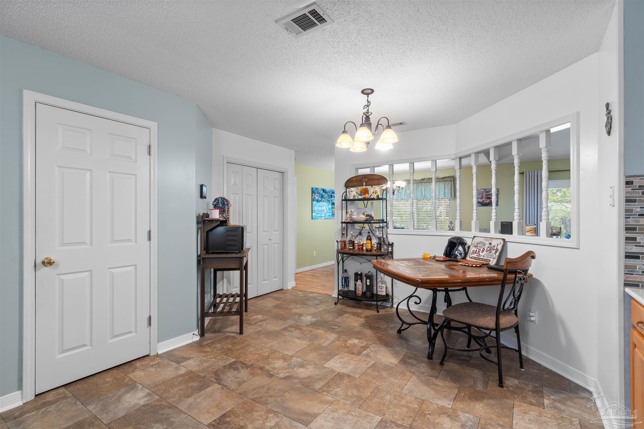 1342 Mazurek Boulevard Pensacola, FL 32514 - Photo 15 of 36 a view of a dining room with furniture and a chandelier