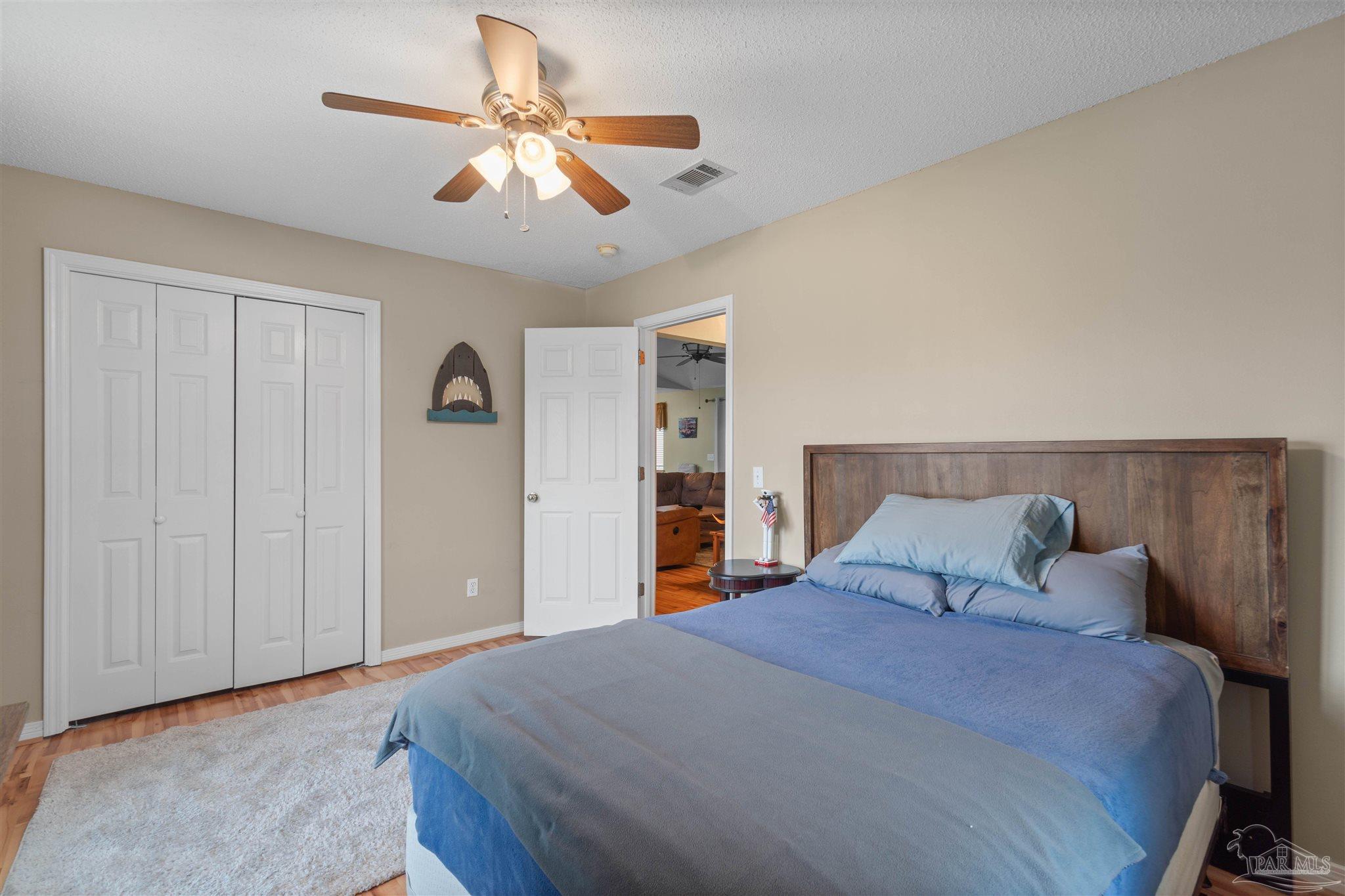1342 Mazurek Boulevard Pensacola, FL 32514 - Photo 17 of 36 a bedroom with a large bed and a chandelier