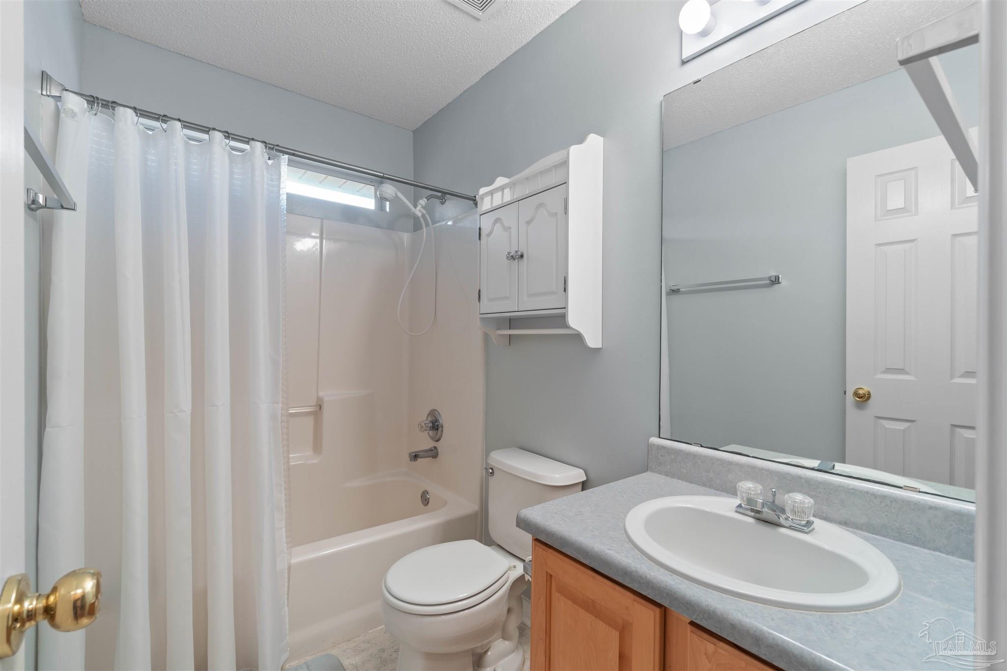 1342 Mazurek Boulevard Pensacola, FL 32514 - Photo 18 of 36 a bathroom with a sink toilet a mirror a vanity and shower