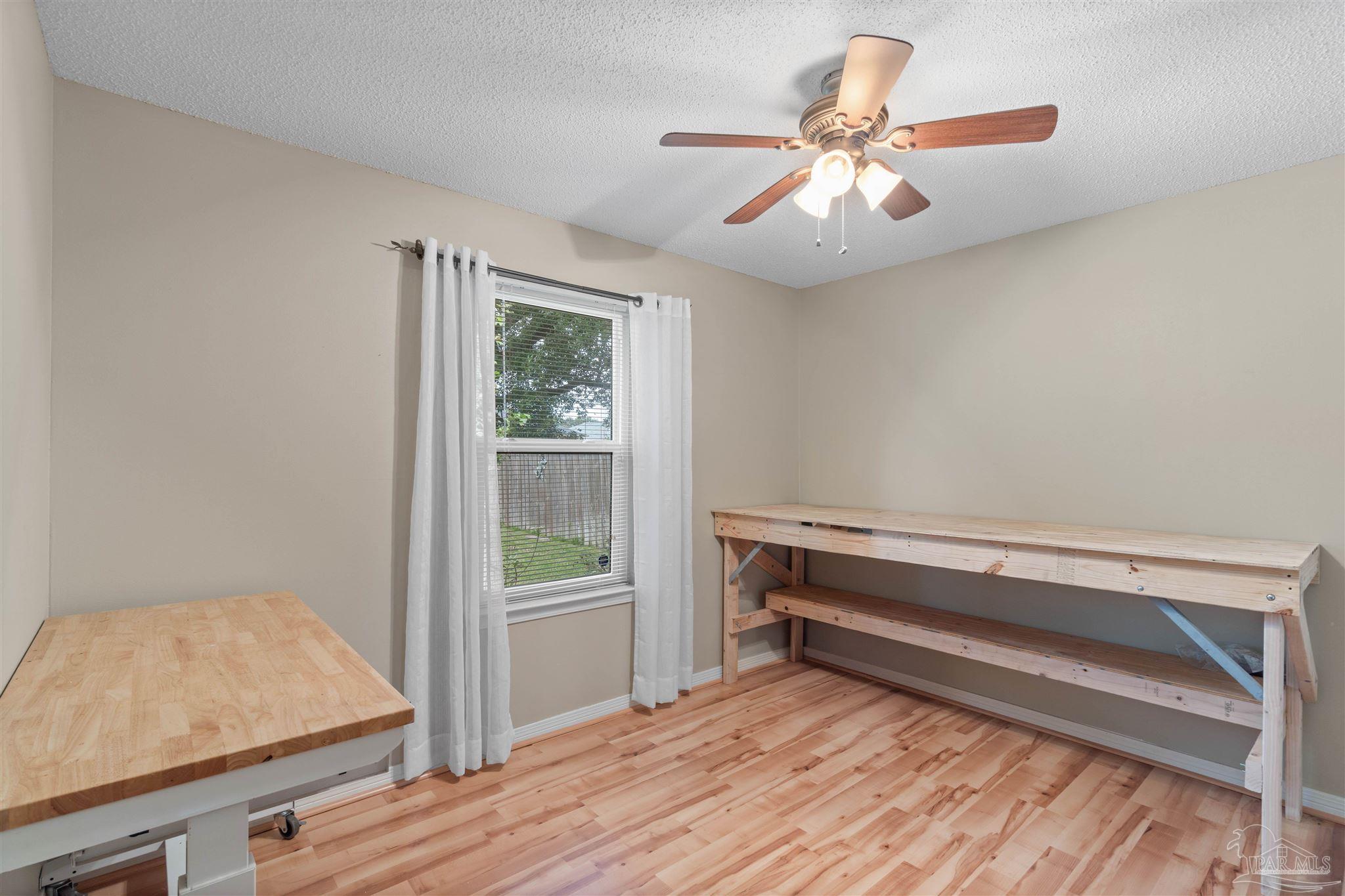 1342 Mazurek Boulevard Pensacola, FL 32514 - Photo 19 of 36 a room with chandelier fan and wooden floor