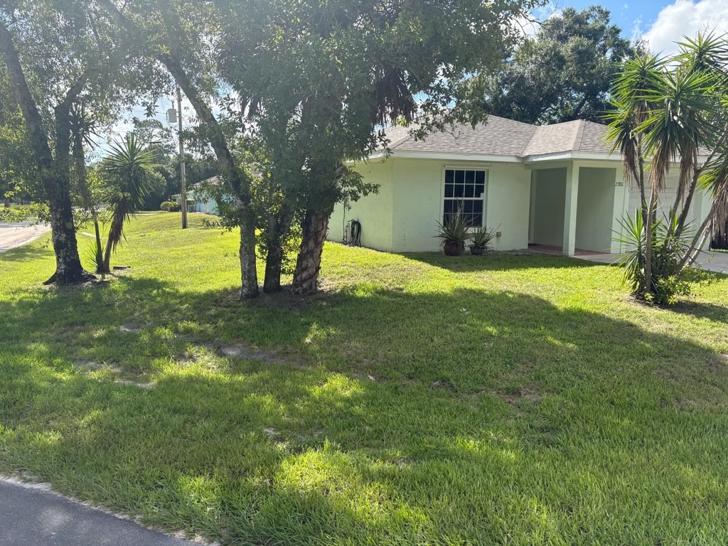 a view of a house with a yard and tree s