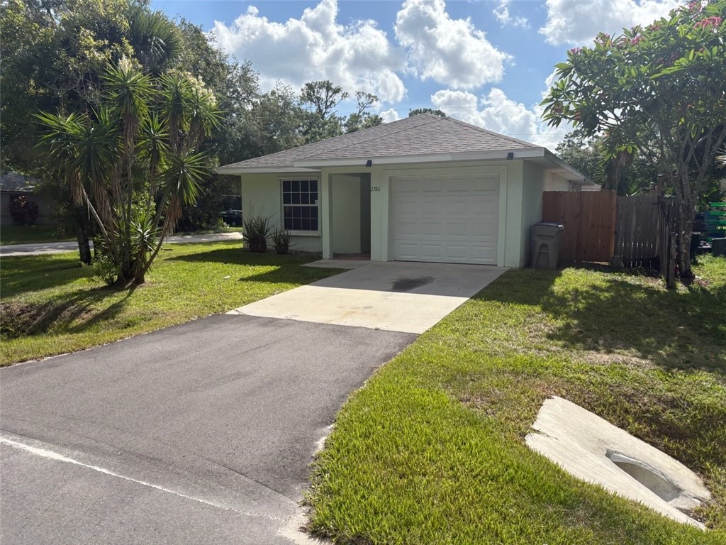 2380 90th Avenue Vero Beach, FL 32966 - Photo 8 of 8 a front view of a house with a yard and garage