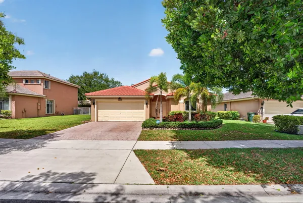 a front view of a house with a yard and a garage