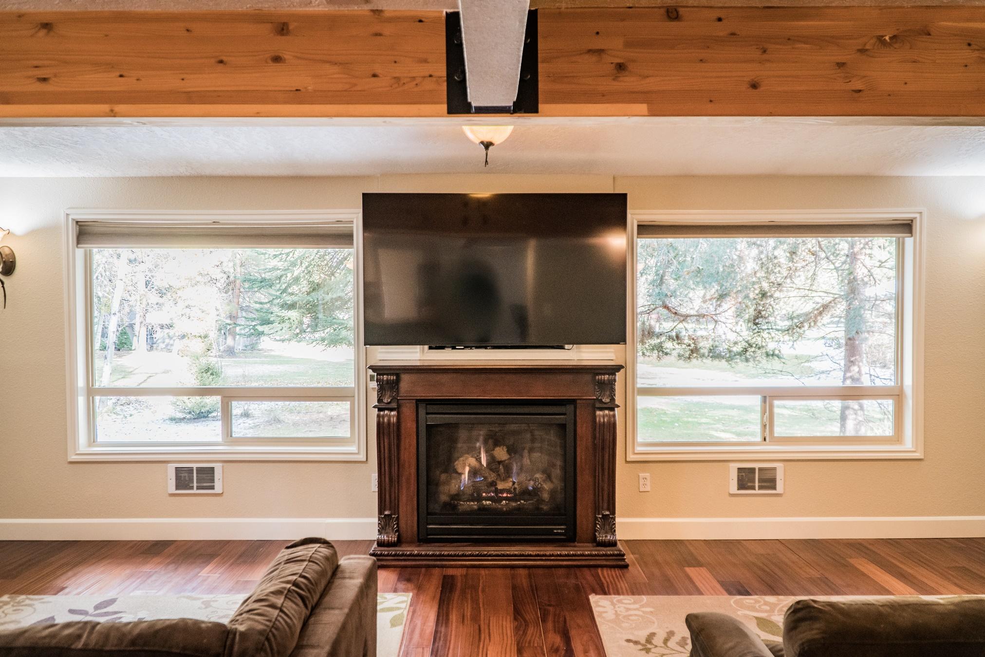 20380 Strawline Road Bend, OR 97702 - Photo 11 of 30 Fireplace is gas and framed by the windows on the sides.