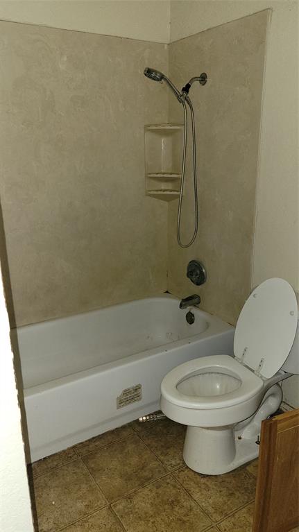 902 South Old Temple Road Hewitt, TX 76643 - Photo 12 of 32 Bathroom featuring a white bathtub, shower surround with integrated shelving, chrome shower fixtures, and a white toilet