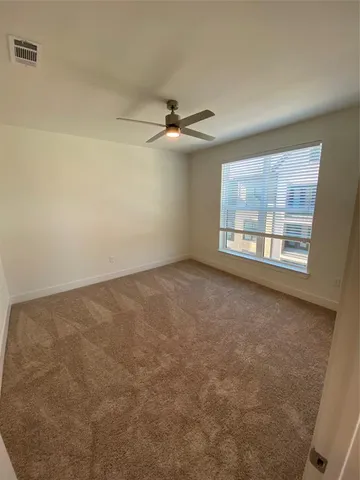 an empty room with windows and ceiling fan view