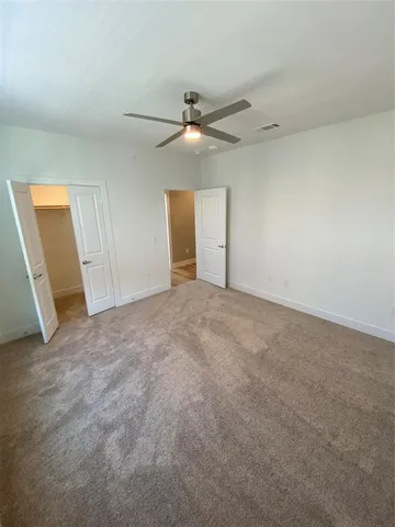 a view of an empty room and a ceiling fan