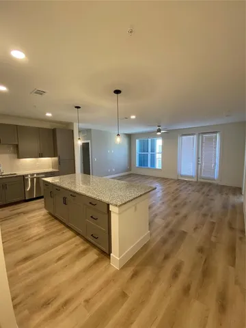 a large kitchen with stainless steel appliances a large counter top and a stove