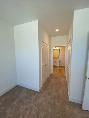 an empty room with closet and a bathroom