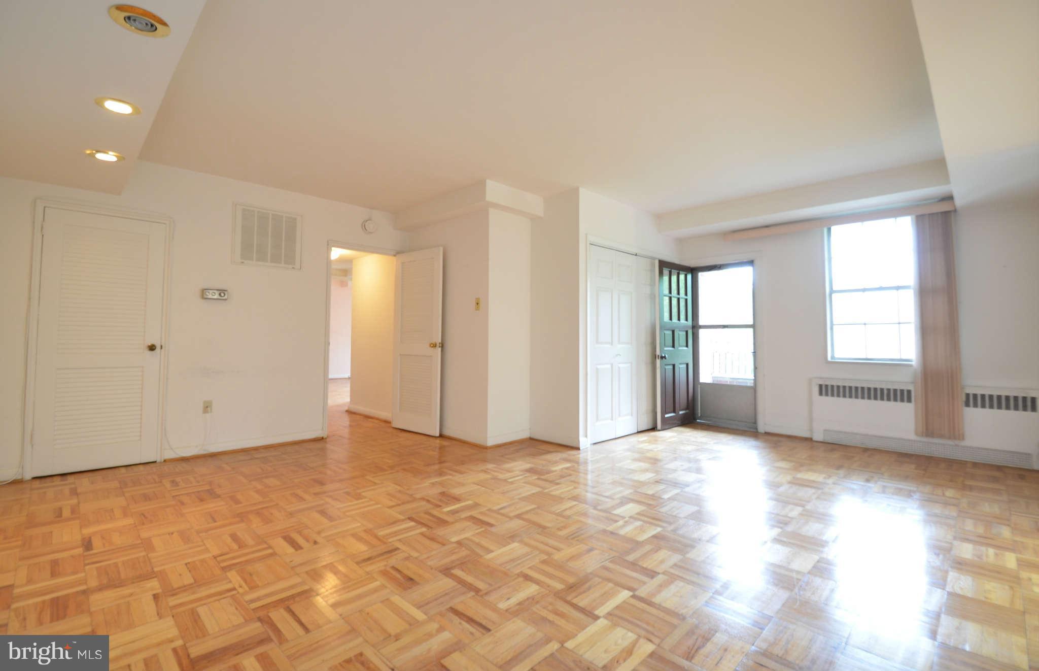 310 Ridgemede Road, Unit 206 Baltimore, MD 21210 - Photo 14 of 17 a view of an empty room with window and wooden floor