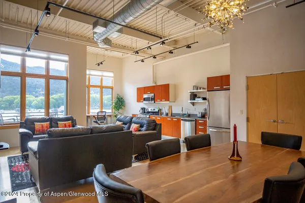 a living room with furniture a flat screen tv and a chandelier