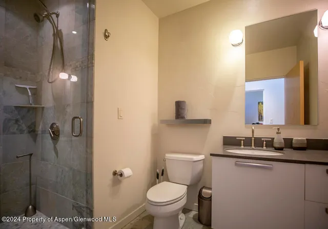 a bathroom with a granite countertop sink mirror vanity and toilet