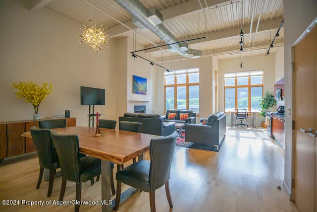 a view of a dining room with furniture a chandelier and wooden floor