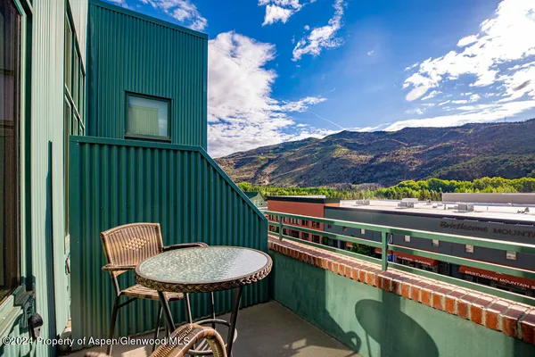 a balcony with a table and chairs