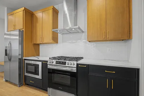 a kitchen with stainless steel appliances granite countertop a stove a sink and a refrigerator