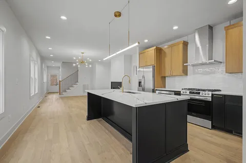 a kitchen with stainless steel appliances granite countertop a sink stove and refrigerator