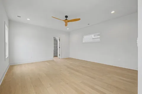 an empty room with a ceiling fan and wooden floor