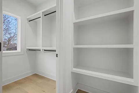 a view of walk in closet with empty racks