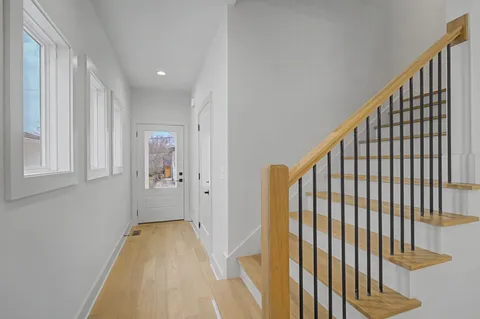 a view of a hallway with wooden floor and staircase