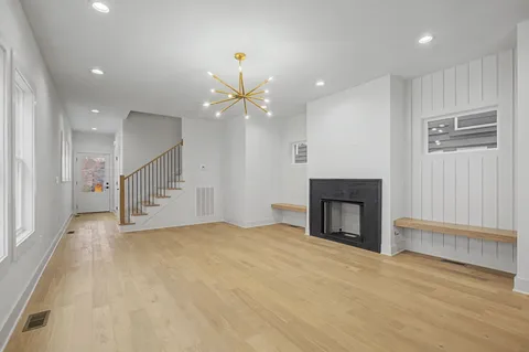 an empty room with kitchen and a fireplace