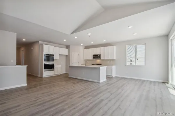 a living room with stainless steel appliances kitchen island wooden floor and view living room
