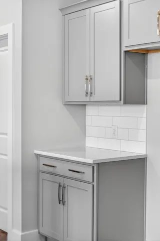 a view of an empty room with chandelier fan