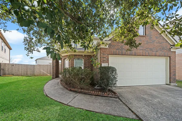 a view of a house with backyard and a tree