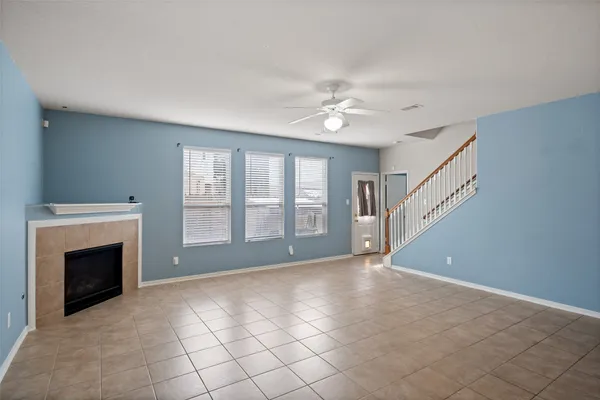 a view of an empty room with window and fireplace