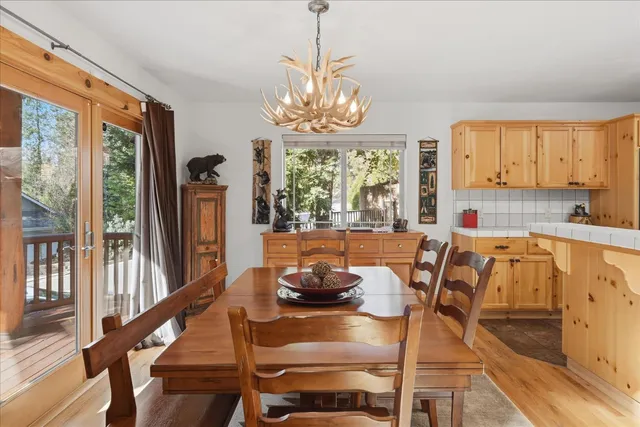 a living room with couches a dining table and kitchen view with wooden floor