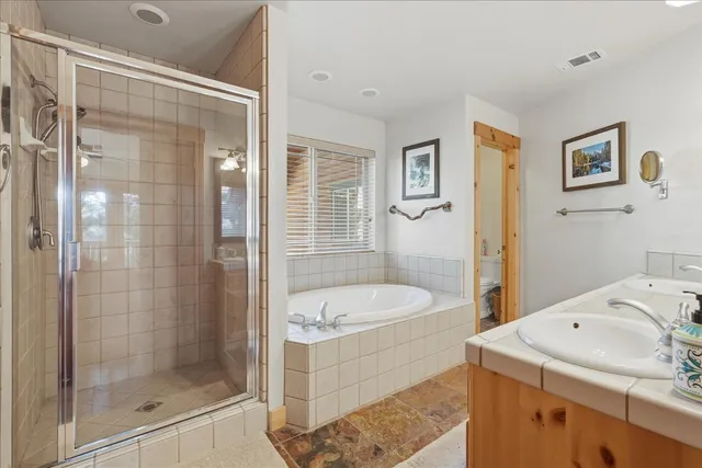 a bedroom with a bed and large windows