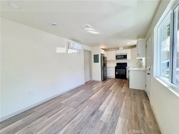 a view of a kitchen with wooden floor and a refrigerator