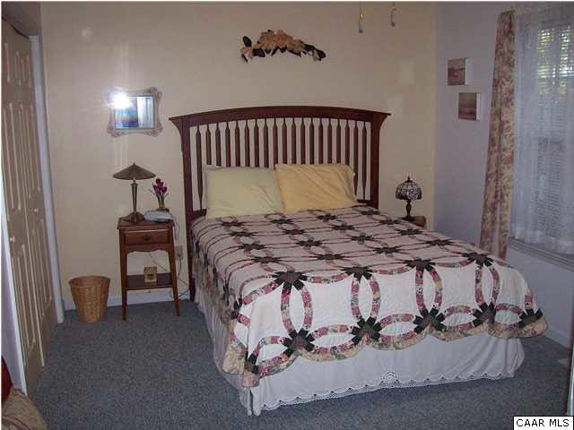 5619 Fredericksburg Road Ruckersville, VA 22968 - Photo 12 of 29 a bed sitting in a bedroom next to a lamp