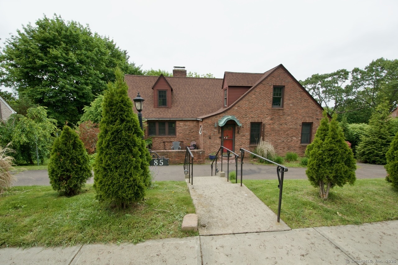 a view of house with a yard and sitting area