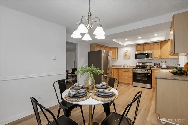 a view of a dining room with furniture a chandelier and wooden floor