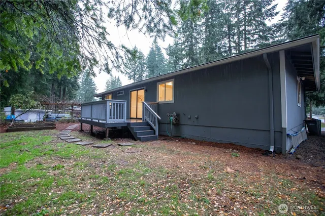 a view of backyard with wooden fence and large trees