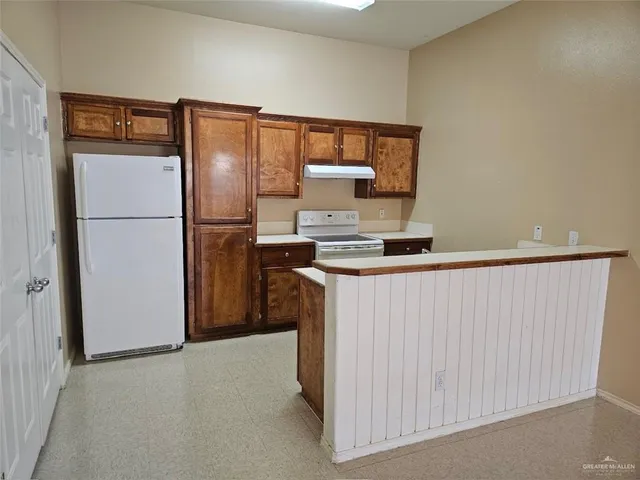 a kitchen with a refrigerator and a stove