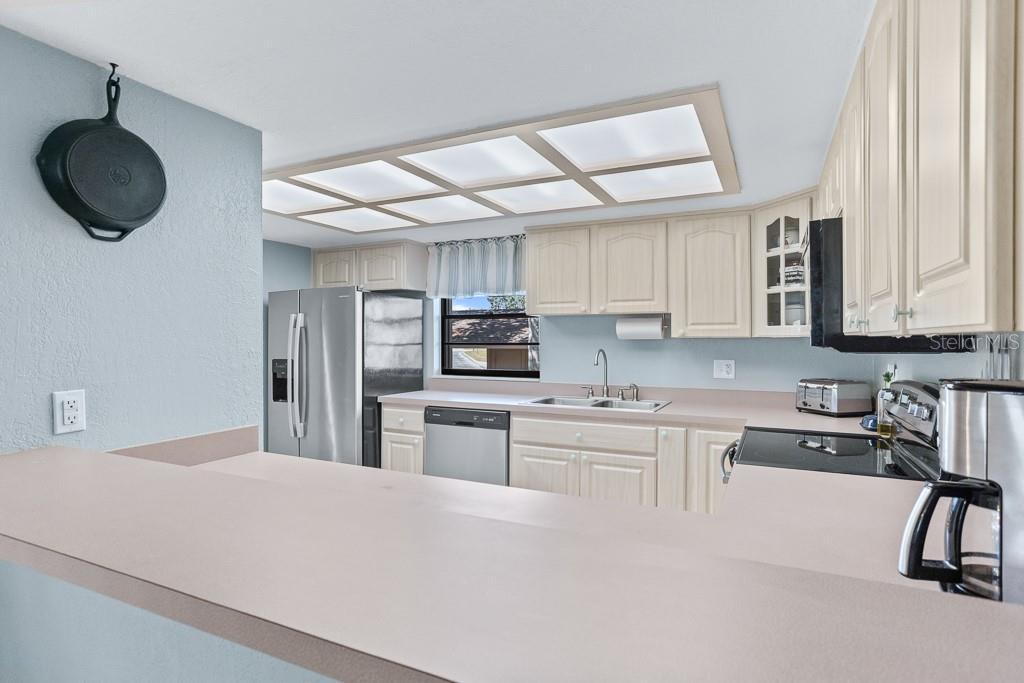 100 Ingrid Place Oldsmar, FL 34677 - Photo 13 of 51 a kitchen with a sink stainless steel appliances and cabinets