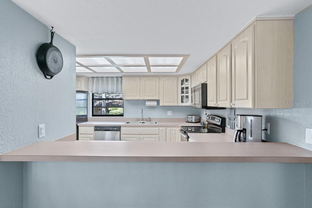 100 Ingrid Place Oldsmar, FL 34677 - Photo 14 of 51 a kitchen with stainless steel appliances a microwave a stove and white cabinets