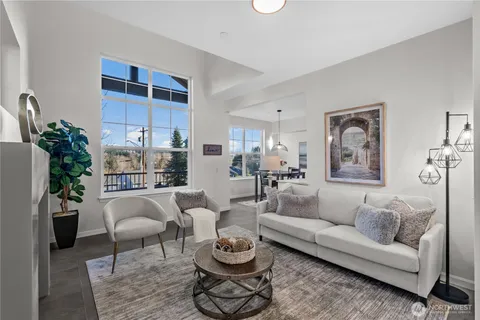 a living room with furniture a rug and white walls