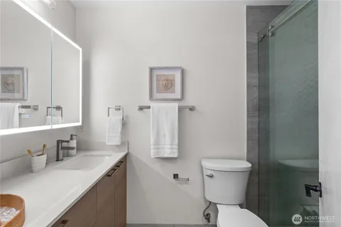 a bathroom with a granite countertop sink mirror vanity and toilet
