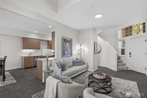 a living room with furniture and a dining table with rug