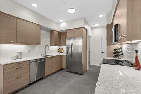 a kitchen with stainless steel appliances a refrigerator sink and cabinets