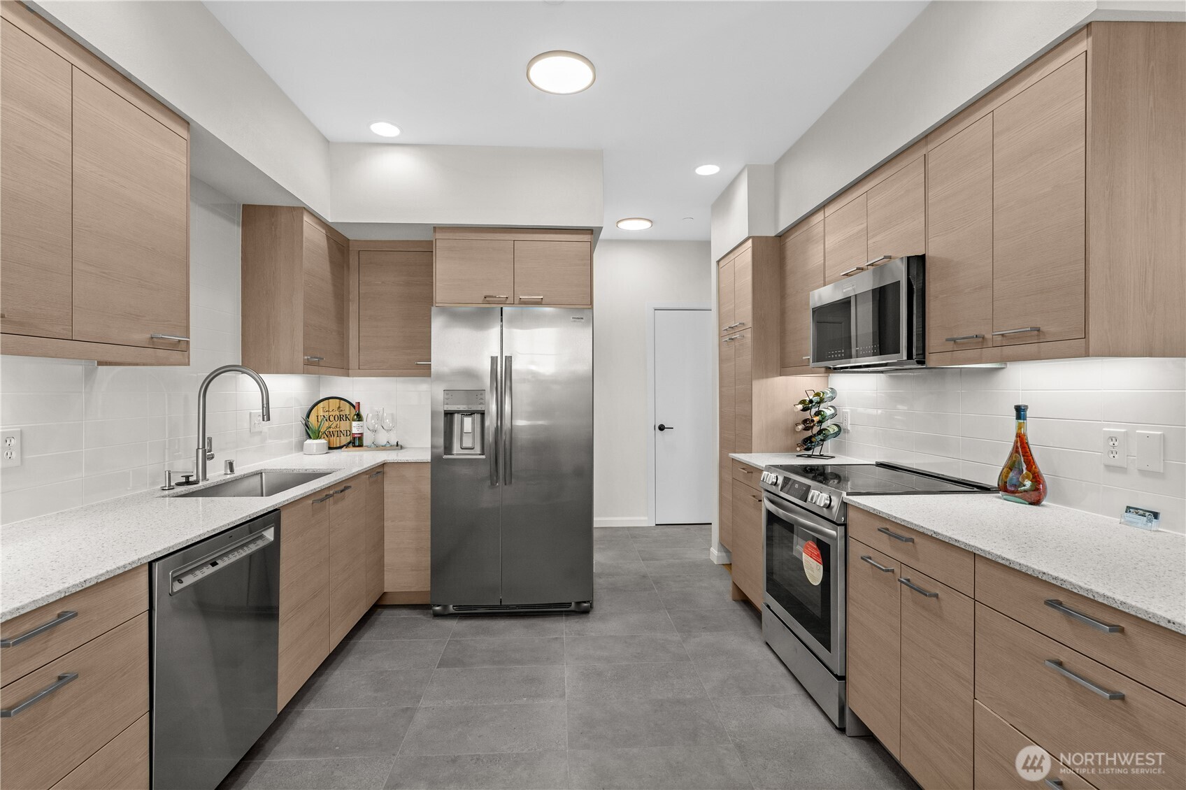 23202 Fitzgerald Road, Unit 1 Bothell, WA 98021 - Photo 8 of 21 a kitchen with stainless steel appliances granite countertop a refrigerator a sink a stove a microwave and island